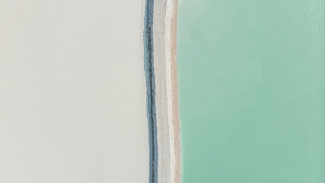 Abstract close-up of white and pale teal surfaces separated by a narrow grey vertical strip.